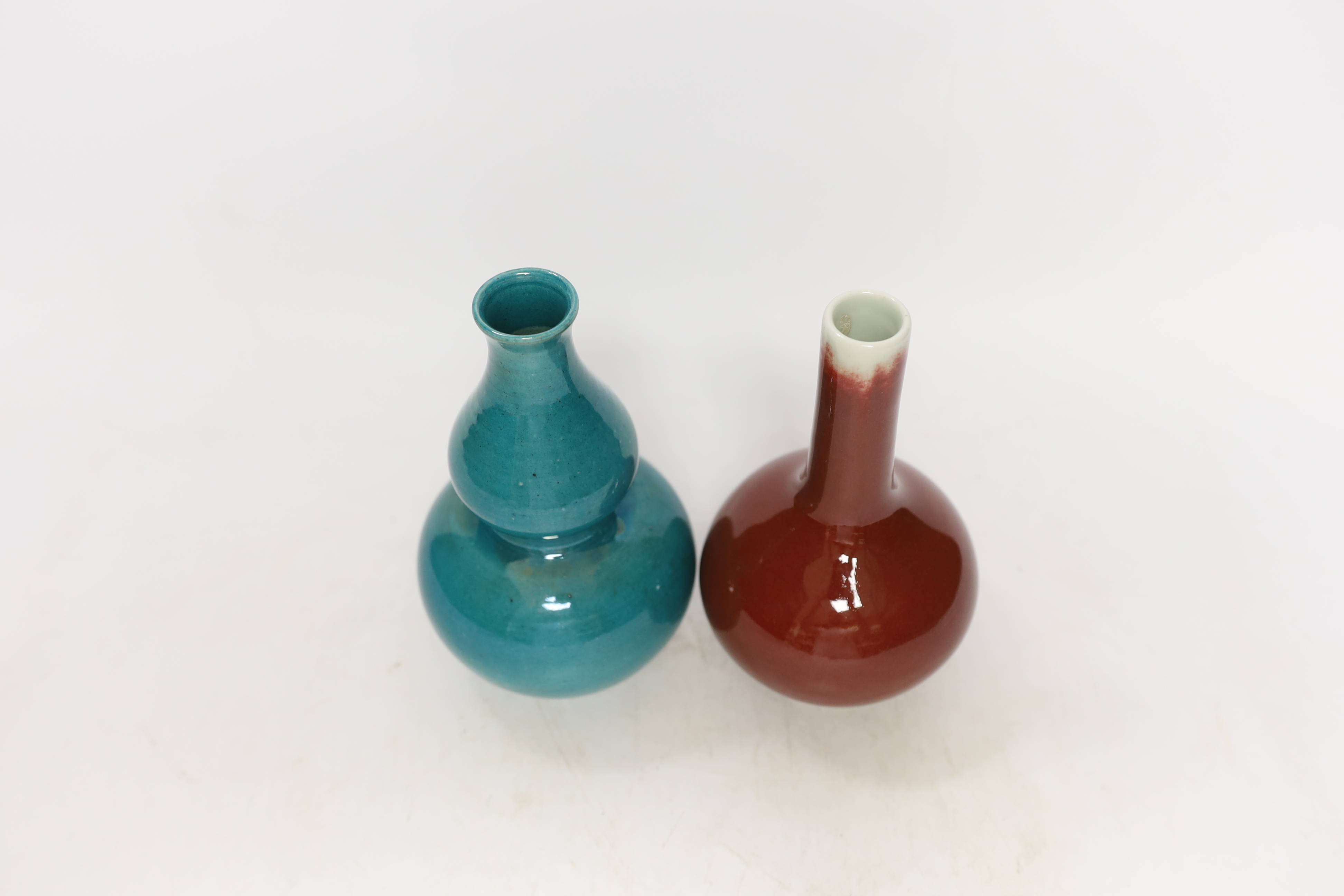 A Chinese monochrome gourd vase together with a similar sang de boeuf bottle vase, tallest 16cm